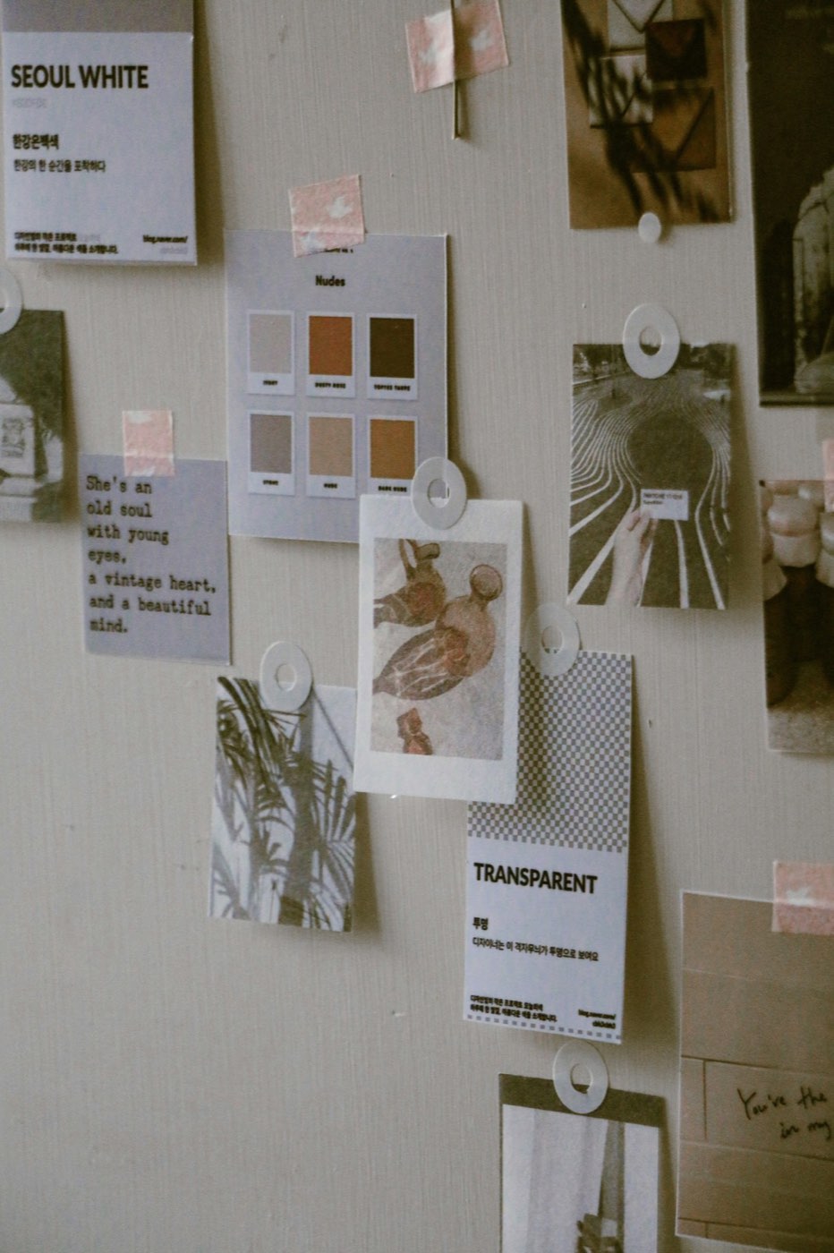 A mood board pinned with a photograph, a written note and paper samples
